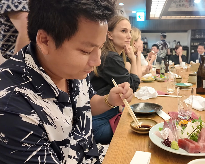 Vlogger sitting next to A-List star at a restaurant, unaware while recording entire video with chopsticks and sashimi.
