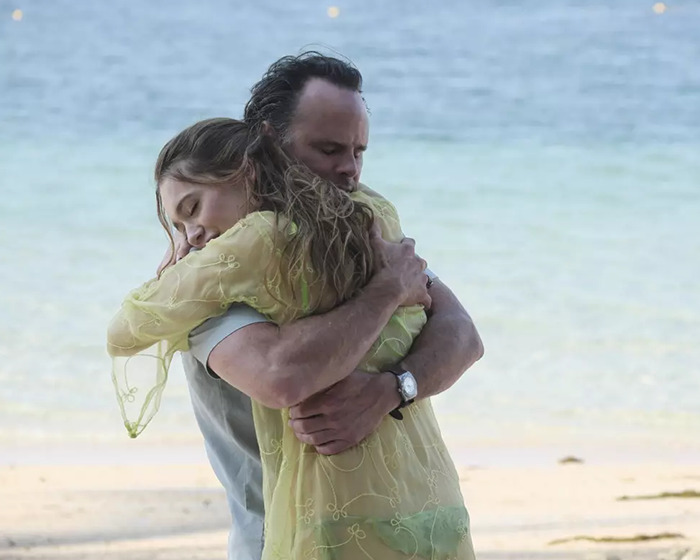Walton Goggins and Aimee Lou Wood hugging on a beach scene, highlighting Walton Goggins off the rails moment.