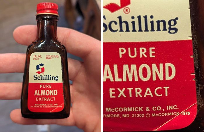Hand holding a vintage bottle of Schilling pure almond extract, an unusual find in old houses.