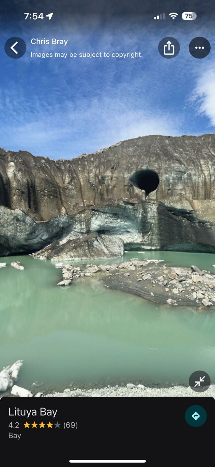 Unusual geological formations with a large cave and greenish bay water seen on Google Earth odd things discovery.