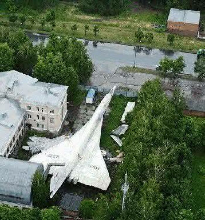 A large, abandoned aircraft surrounded by trees and buildings, one of the odd things found on Google Earth.