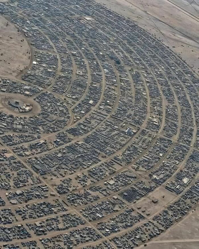 Aerial view of a large, densely packed settlement with curved road patterns, an odd find on Google Earth.