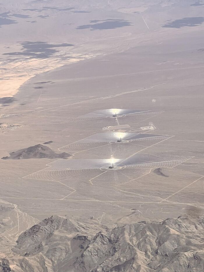 Aerial view of solar power towers shining brightly in a desert, an odd thing found on Google Earth images.