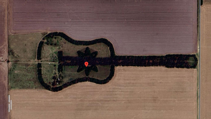 Aerial view of a guitar-shaped field with a star design, one of the weird things on Google Earth that intrigue viewers.