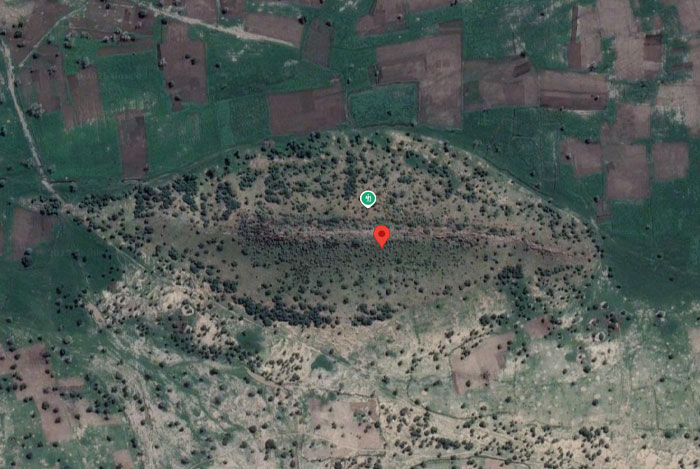 Aerial view of a large, unusual land formation surrounded by fields, showing weird things on Google Earth.