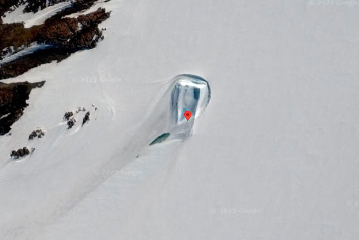 Satellite view on Google Earth showing a strange icy formation with a red location marker in a snowy landscape.