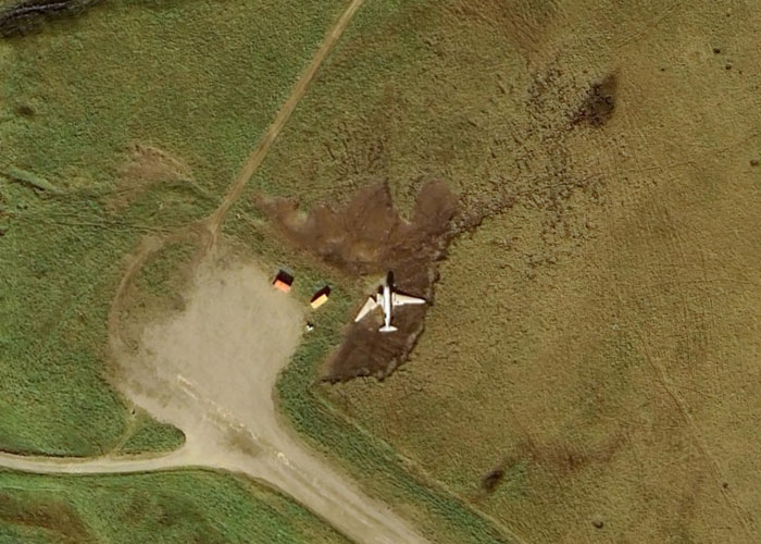 Aerial view of a plane crash site in a grassy area showing weird things on Google Earth that will make you question everything.