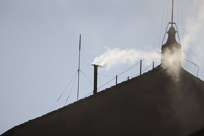 White smoke rising from chimney signaling new pope has been chosen during the papal conclave announcement.