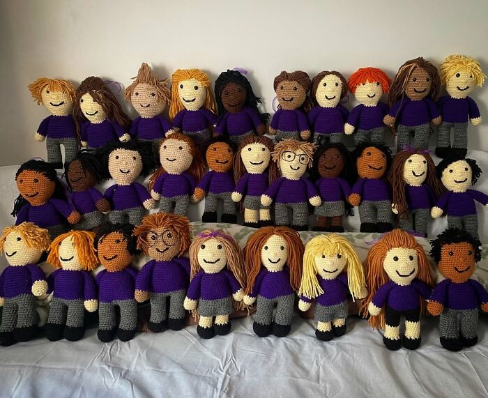 Handmade crocheted dolls representing diverse teachers showing love for students and chosen profession in purple sweaters.