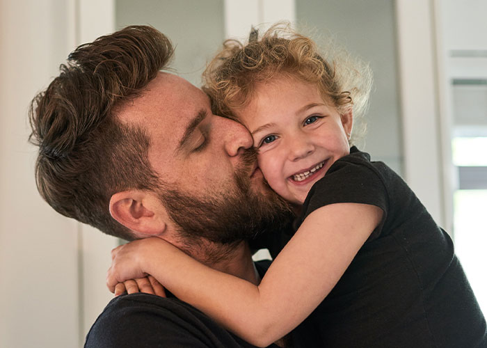 Father teaches daughter basic tasks after wife&rsquo;s passing while sharing a loving moment at home in a bright room.