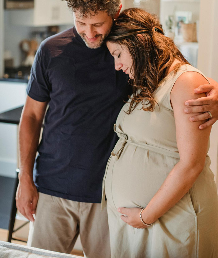 Pregnant woman and boyfriend embracing tenderly, capturing a moment before revealing secret wife and impending childbirth.