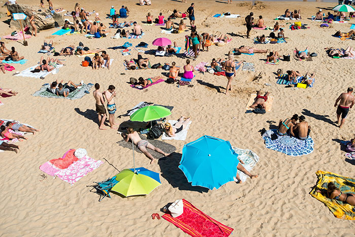 Crowded beach scene with people sunbathing and colorful umbrellas, illustrating social reactions to a woman feels betrayed. Crowded beach scene with people sunbathing and colorful umbrellas, illustrating social reactions to a woman feels betrayed.