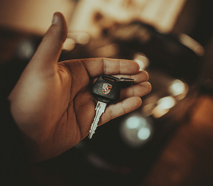 Hand holding a car key, illustrating unhinged safety habits shared by women that might actually save lives.