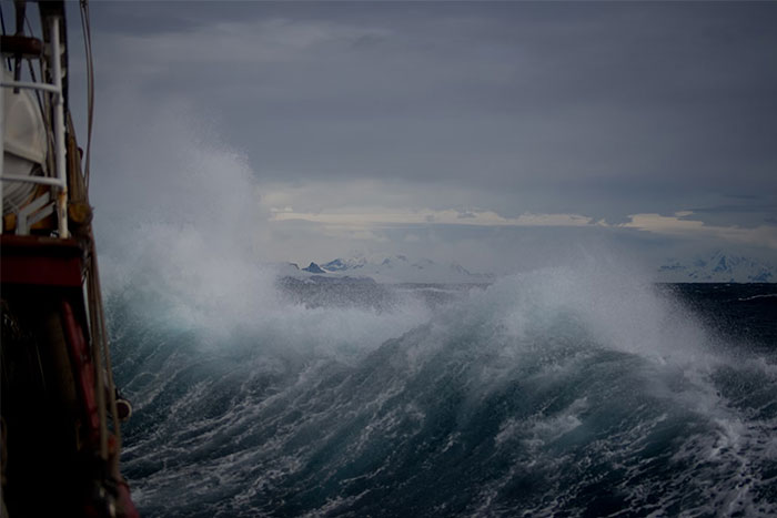 Rough sea waves crashing near a ship, capturing the eerie atmosphere experienced by people who worked at sea.