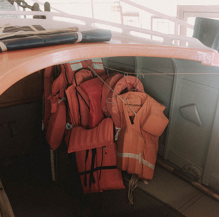 Orange life jackets hanging inside a boat cabin, representing the atmosphere of people who worked at sea witnessing creepy moments.