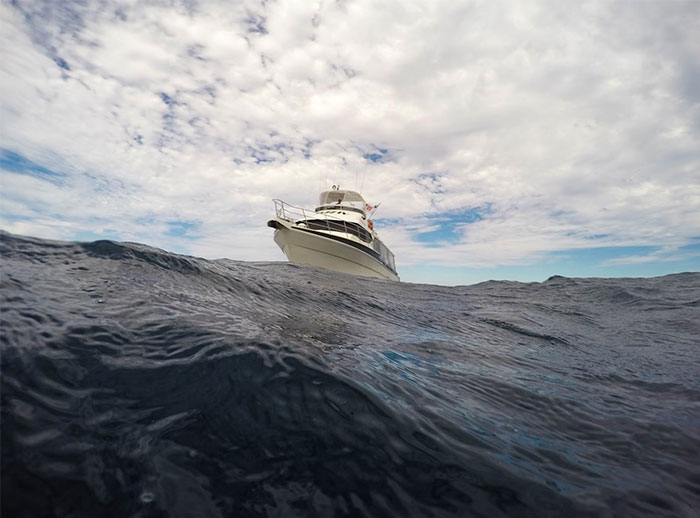 Boat floating on dark choppy sea under a cloudy sky, illustrating eerie experiences from people who worked at sea.