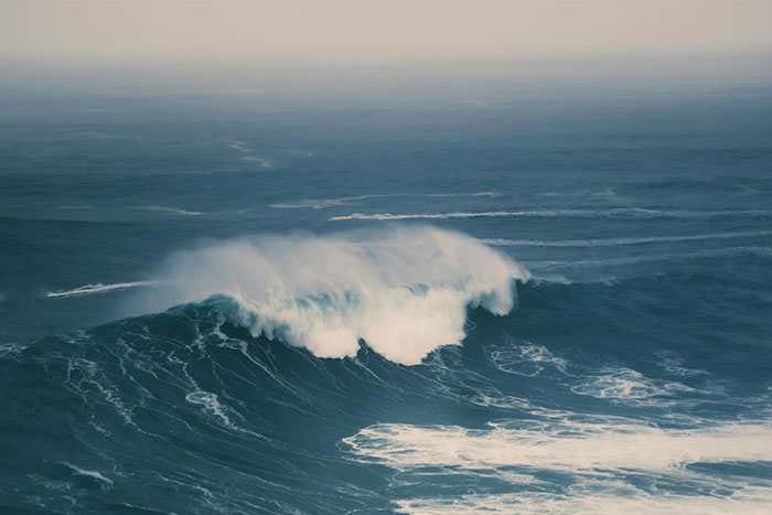 Rough ocean waves at sea with mist rising above the water, capturing the eerie atmosphere witnessed by people who worked at sea.