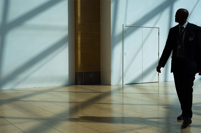 A silhouette of a man in suit walking in a modern lobby, offering a glimpse into the world of the ultra wealthy.