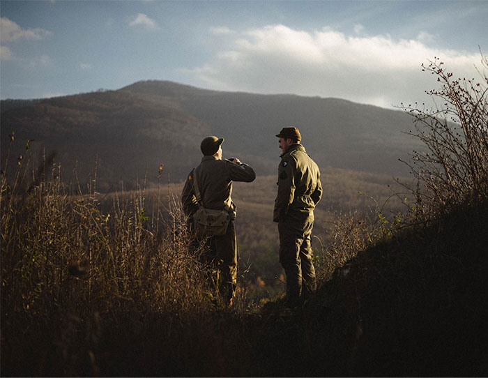 Two men dressed in outdoor gear enjoying a scenic view, offering a glimpse into the world of the ultra wealthy.
