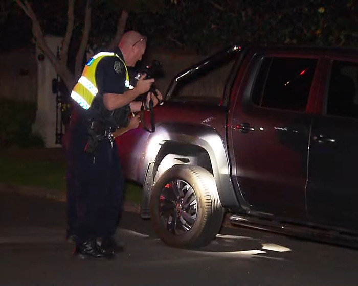 Police officer examining a vehicle involved in a fatal crash connected to cyclist avoiding jail in a tragic incident.