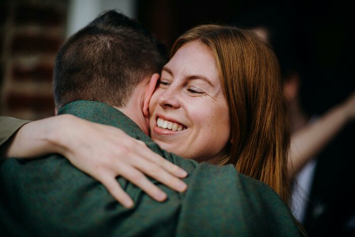 Woman smiling warmly while hugging a man, illustrating kindness and harmony as a secret to longevity and aging well.
