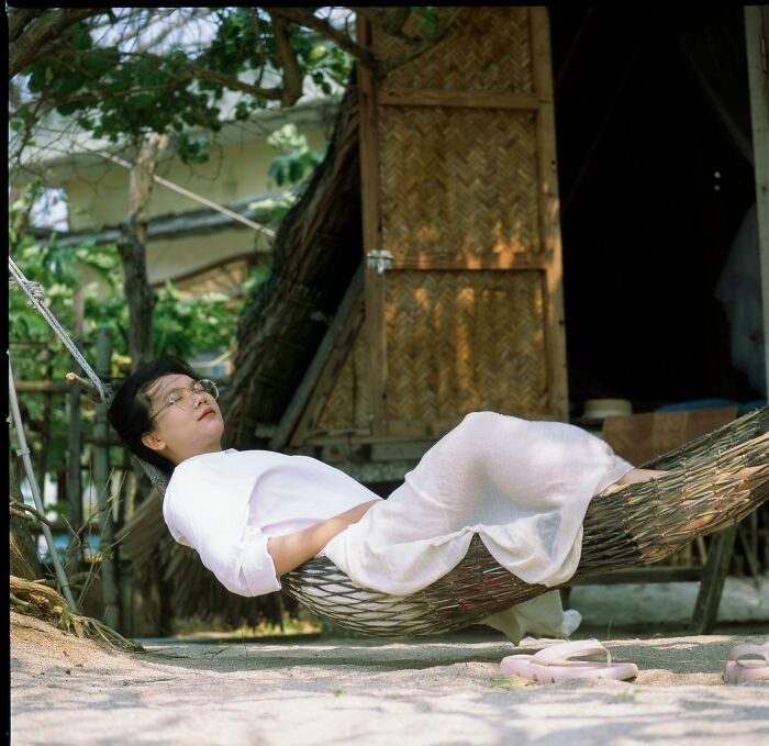 115YO lady relaxing on a hammock outdoors, embodying the world's oldest human with a peaceful and calm demeanor.