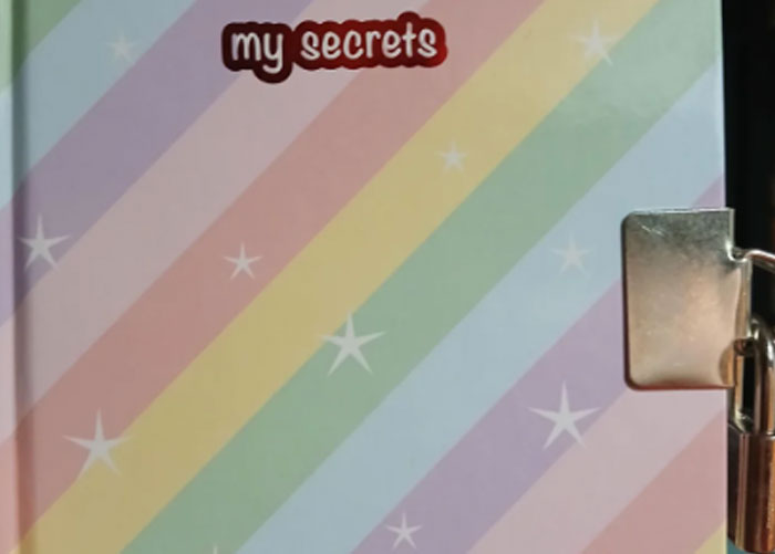 Rainbow-striped journal with the words my secrets on cover, symbolizing worst gifts people have shared.