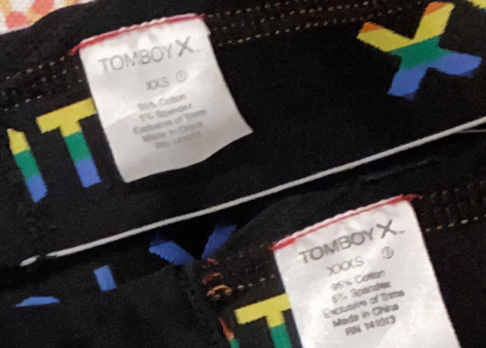 Close-up of clothing labels on black fabric with colorful letters, depicting some of the worst gifts people have received.
