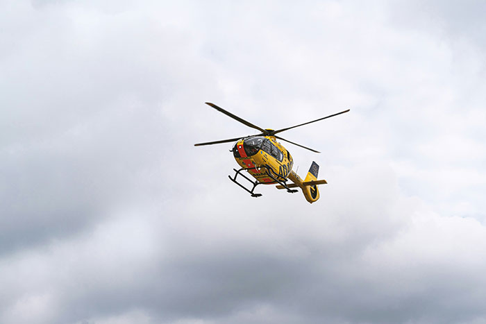 Yellow and black helicopter flying under cloudy sky illustrating helicopter parenting concept in a humorous way