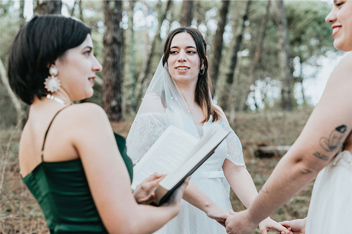 Bride and guests holding hands during an outdoor wedding ceremony, capturing chaotic moments witnessed at a wedding.