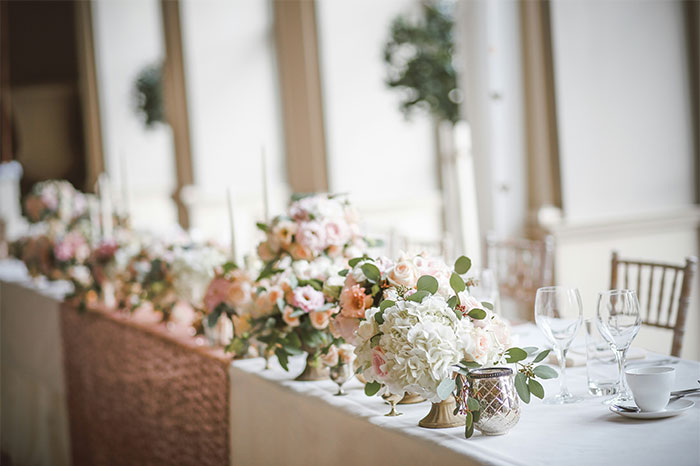 Wedding table decorated with floral centerpieces and glassware, capturing moments of chaos witnessed at a wedding event.