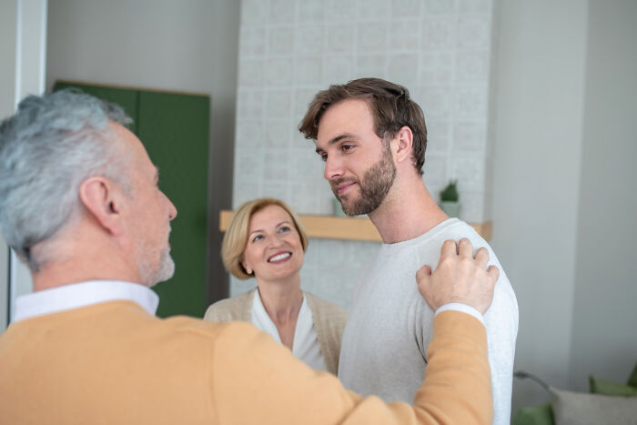 Young man receiving comforting support from parents, illustrating the emotional impact of hurtful things moms said to them.