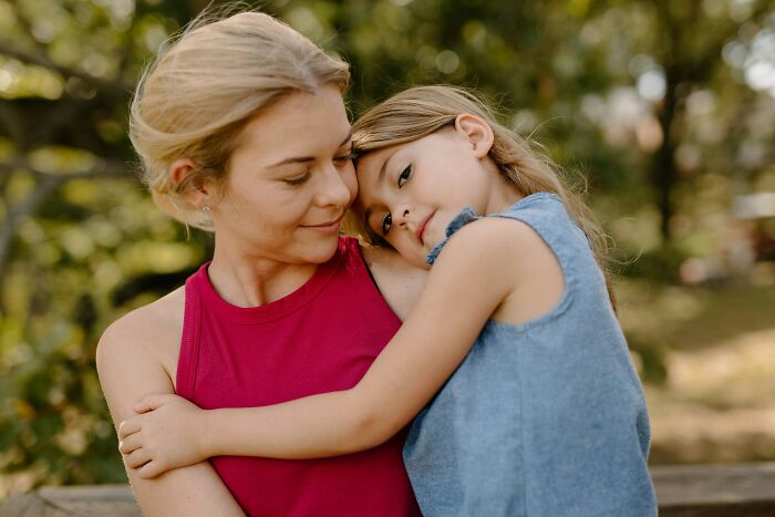 Mother and daughter sharing a tender moment outdoors, reflecting on the impact of hurtful things moms ever said to them.