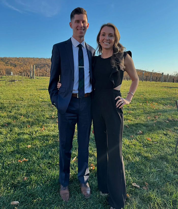 Couple dressed formally outdoors with woman smiling, illustrating woman signing husband up for marathon with no training.