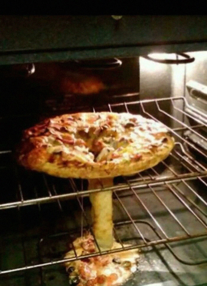Pizza melting in oven creating a confusing mushroom-like shape, showcasing one of the funny pics people had to take.