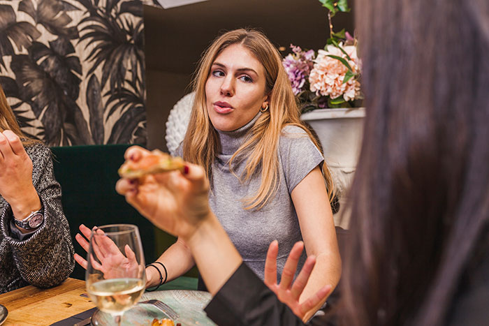 Woman frustrated during family dinner clapping back at cousin insulting her wedding and relationship status