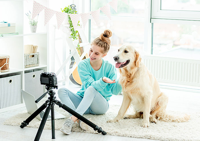 A young woman sitting with her dog in a bright room, preparing for a maternity shoot with an aesthetic focus. A young woman sitting with her dog in a bright room, preparing for a maternity shoot with an aesthetic focus.