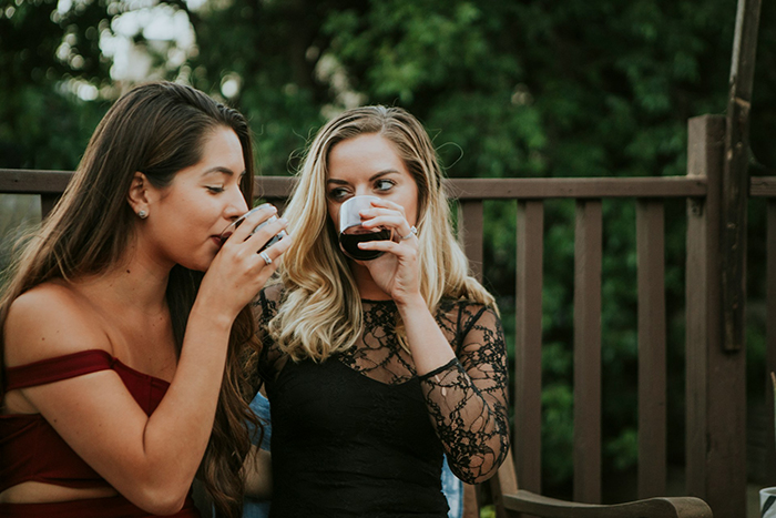 Two women enjoying drinks outdoors, capturing a moment related to rebooking a flight to avoid babysitting a niece. Two women enjoying drinks outdoors, capturing a moment related to rebooking a flight to avoid babysitting a niece.