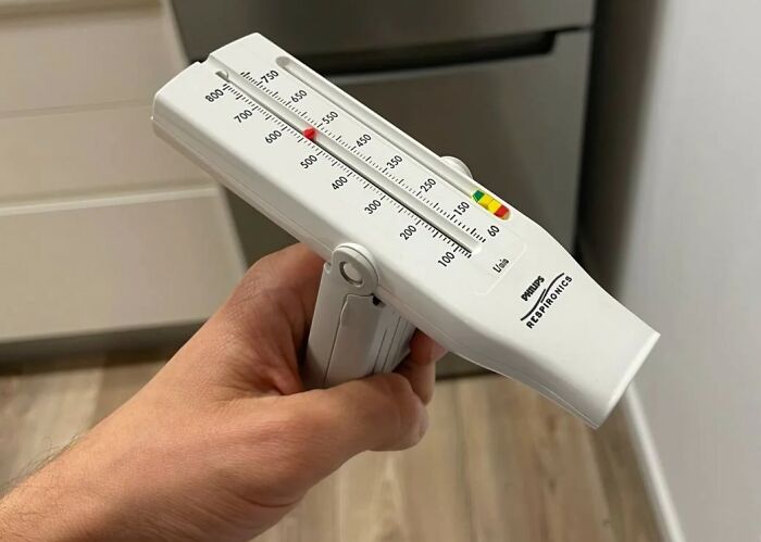 Hand holding a spirometer device, one of the unexpected items causing issues at airport security checkpoints.