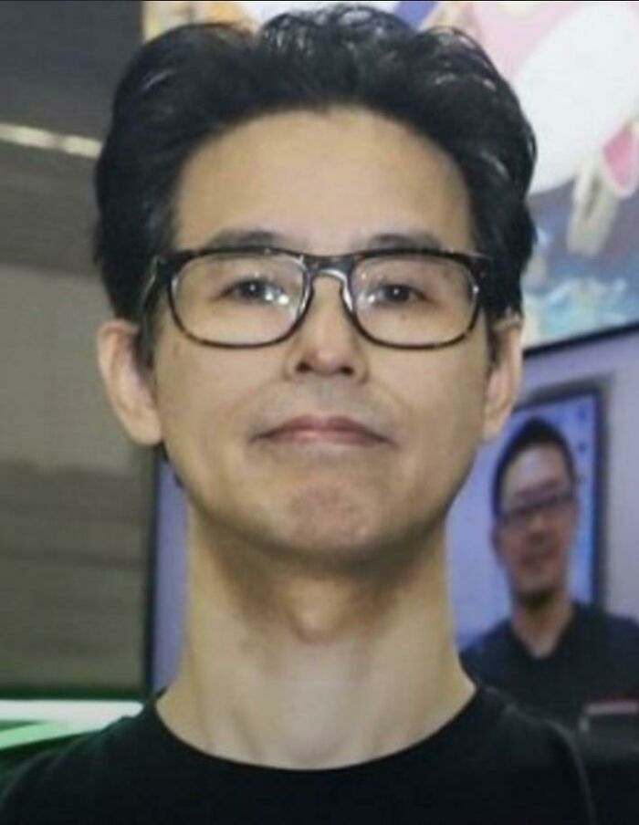 Man with glasses in a black shirt, posing indoors with a thoughtful expression, related to traumatizing the next generation.