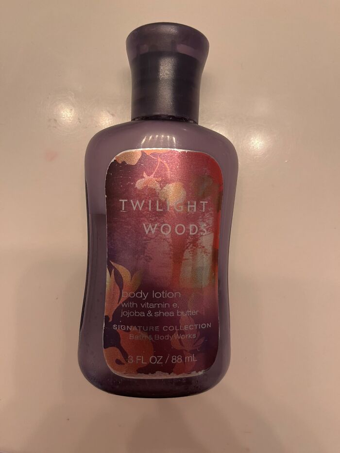 Purple Twilight Woods body lotion bottle from Bath & Body Works on a beige surface, showing product label details.