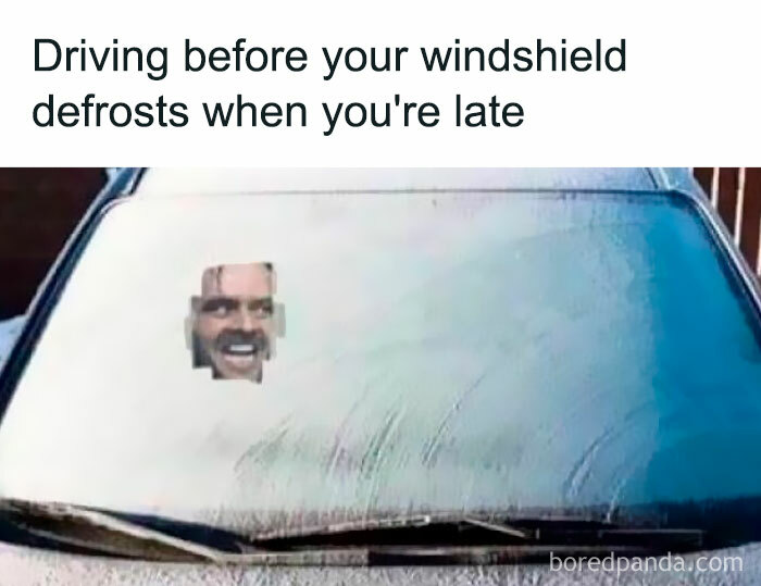 Car windshield with a small defrosted area showing a man’s smiling face, a relatable meme about being late.