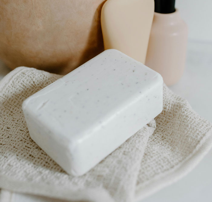 Bar of soap and natural skincare tools on a textured cloth illustrating effective old wives' tales in home remedies.