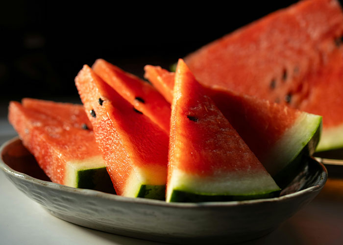 Slices of fresh watermelon on a plate, illustrating a buffet food item related to buffet workers' wildest encounters.