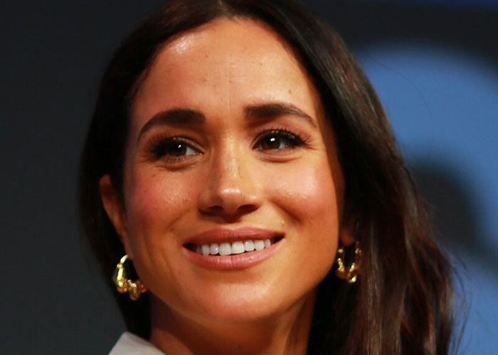 Close-up of a smiling woman wearing gold hoop earrings, representing celebrities before fame and their early careers.