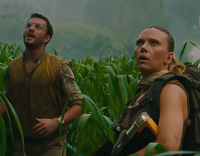 Scarlett Johansson and costar exploring a dense cornfield, showcasing a tense and adventurous movie scene.