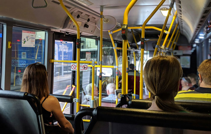 People riding a city bus focused on their journeys, illustrating college life and secrets of how to pay for college.