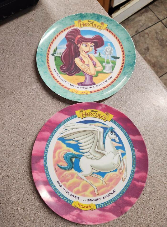 Two Disney Hercules collectible plates featuring Megara and Pegasus, on a kitchen countertop, nostalgic 90s decor.