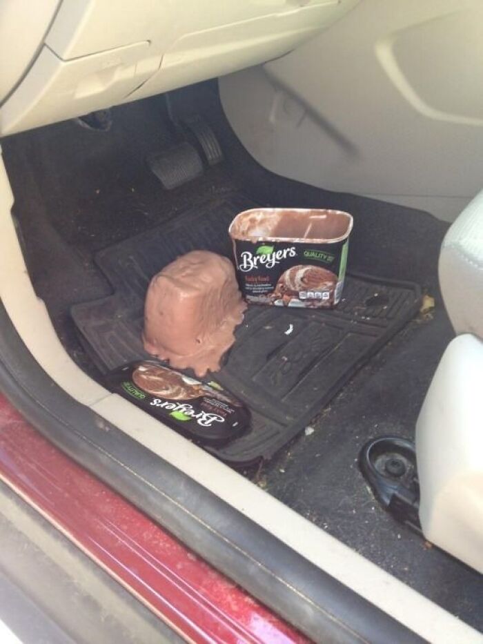 Melted Breyers chocolate ice cream spilled on car floor mat creating a messy and cursed food picture.