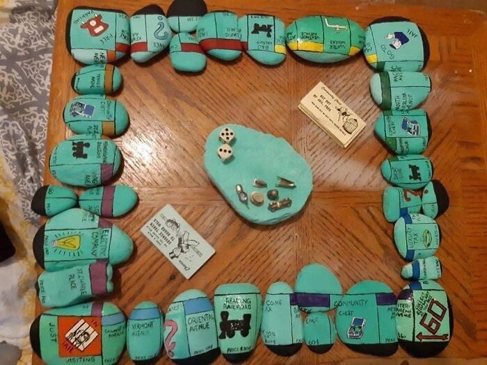 Homemade board game pieces made from painted stones with hand-drawn details, showcasing unusual craftwork mistakes.